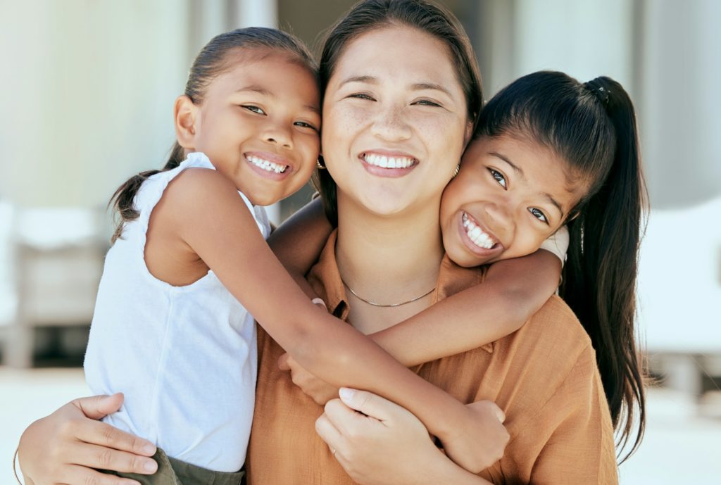 Happy, portrait and children hugging their mother with a smile, love and care outside their house.