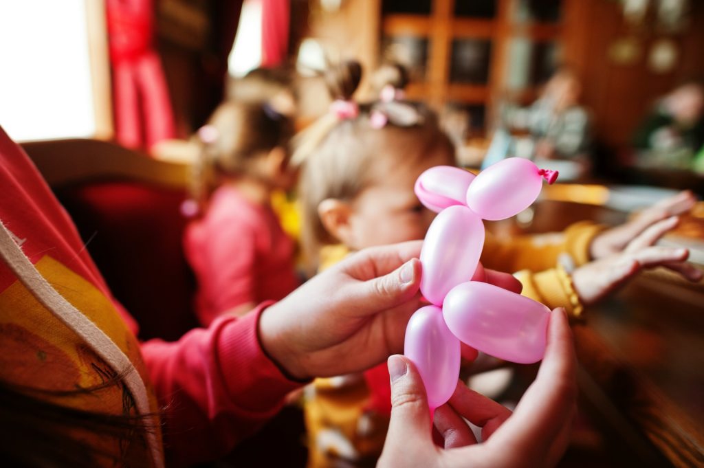 Children at birthday party make balloons animals.